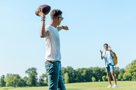 Multiethnic Teenage Boys Playing With Rugby Ball In Park