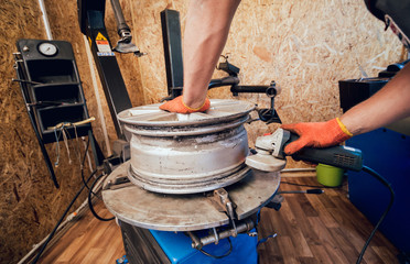 Professional car mechanic replace tire on wheel.