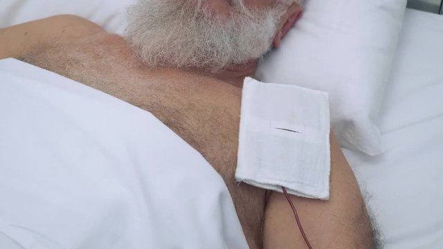 Senior man at the procedure of electrophoresis in clinic