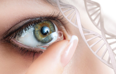 Woman wearing contact lens among DNA stems.