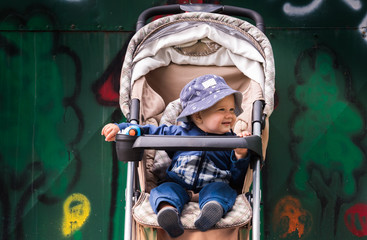 Fototapeta na wymiar Baby boy sitting in the strolling stroller