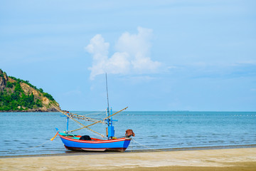 Fishing boat on the beach with blue sky and sea.
