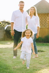 Fototapeta premium selective focus of little kid running while parents standing behind on backyard