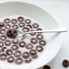 Breakfast with corn rings, milk and cocoa on a white background.