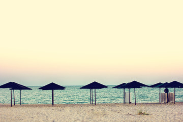 Empty beach, beach umbrellas and beautiful sunset. Romantic atmosphere.