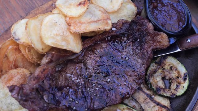 Hot griled appetite ribs with vegetables grill, baked potatos, white creamy sauce, red B-B-Q sause, restaurant fresh air dish