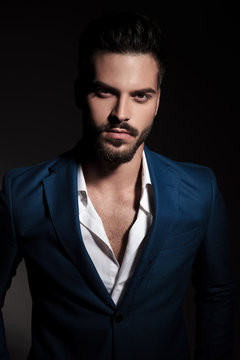 portrait of young man with beard wearing a blue suit