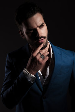 pensive smart casual man on black background looks to side
