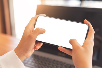 Woman hands using horizontal white screen smartphone mockup for graphic display montage.