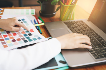 Artist creative designer hand using laptop sketch layout design,Creative designer choosing color samples for design project.