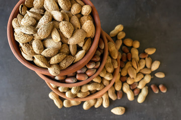  Assortment of nuts in their shell. Different kinds of nuts in  bowls. Healthy food. Selective focus.