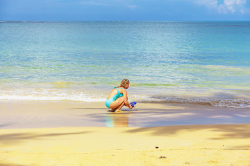 Fototapeta na wymiar Girl playing on the beach