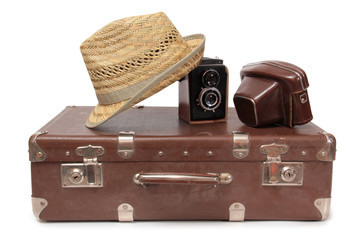 Vintage suitcase and old camera on a white background