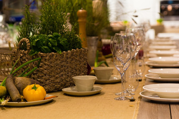 Empty wine glasses, cups and basket with greenery