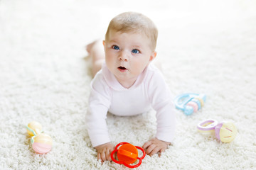 Cute baby girl playing with colorful pastel vintage rattle toy
