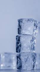 Ice cubes covered with drops of water stand on top of each other. Frozen water in form of a cube, ice. Critically pure ice.