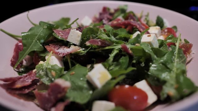 A plate with the spanish cheff salad with goat cheese, jamon and green rucola