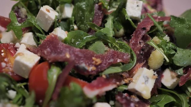 A plate with the spanish cheff salad with goat cheese, jamon and green rucola