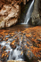 Beautiful river waterfall in autumn forest, a small waterfall part of Fotinski Waterfalls, Rhodope Mountains, Bulgaria