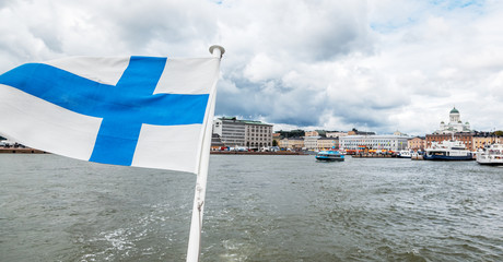 A Finnish flag on a boat, develops in the wind with a view of the sea. Travel to Finland,...