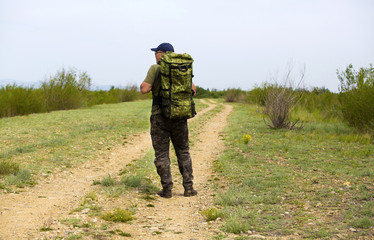A traveler is walking along the road with a backpack