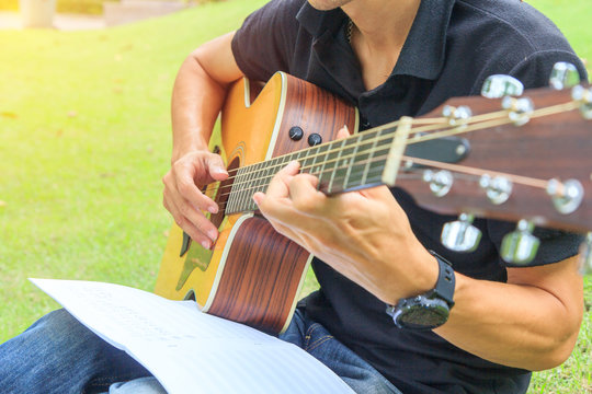 Musician playing guitar in the park