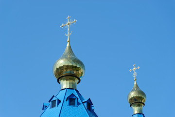 Fototapeta na wymiar Blue roofs of russian orthodox church against clear blue sky. Cathedral of Our Lady of Kazan in Komsomolsk-on-Amur in Russia
