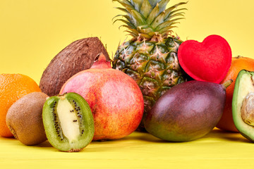 Assortment of ripe tropical fruits. Composition from colorful fruits on yellow background. Fruits and love.