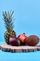 Assortment of exotic fruits on round wood. Composition of ripe tropical fruits. Healthy eating and diet.