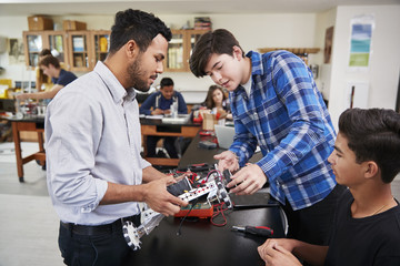 Teacher With Male Pupils Building Robotic Vehicle In Science Lesson - obrazy, fototapety, plakaty