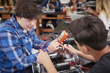 Two Male Pupils Building Robotic Vehicle In Science Lesson