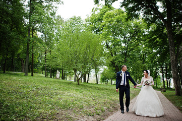 Wedding couple walking and enjoying themselves in the park on a beautiful day.