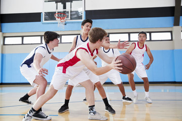 Fototapeta premium Male High School Basketball Team Dribbling Ball On Court