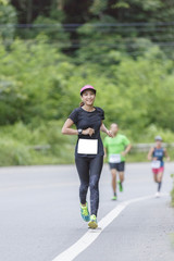 Woman asian Marathon running race, Run up the mountain road.