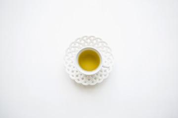 Fresh fragrant and healthy herbal or green tea in a mug on a white surface