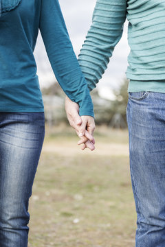 the hands of a woman and a man entwined as a happy couple
