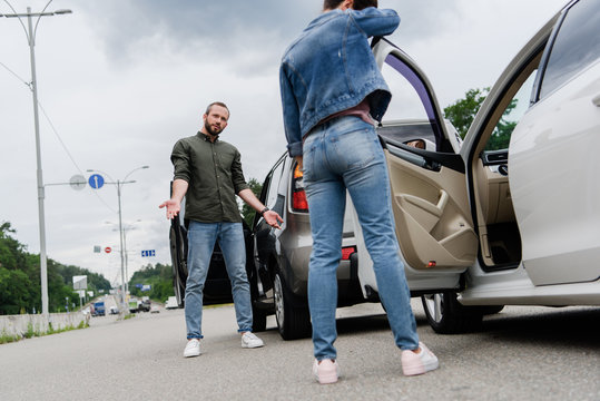 Low Angle View Of Drivers Standing Near Cars On Road After Car Accident