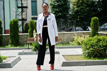 African american doctor female at lab coat with stethoscope outdoor.