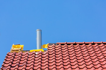 New roof with roof tiles and chimney pipe