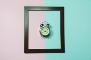 Top view of alarm clock in middle of frame on colorful background and copy space for insert text.