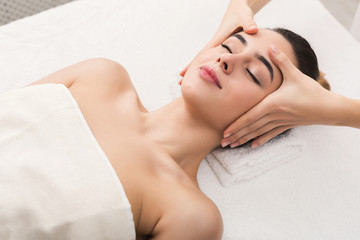 Woman getting professional facial massage at spa salon