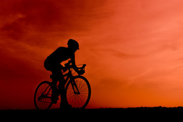 Fototapeta na wymiar Silhouette of the cyclist riding a road bike at sunset.Mountain bicycle and man.Life style outdoor