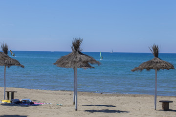 image of Caribbean beach umbrellas in straw, desolate with the sea in the background