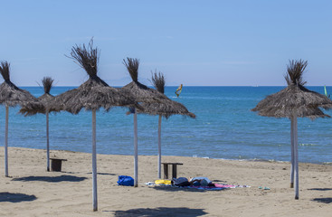 image of Caribbean beach umbrellas in straw, desolate with the sea in the background