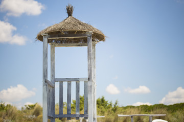 close-up with detail of lifeguard tower with thatched roof