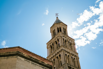 Fototapeta na wymiar View of the spectacular tower of the Cathedral of Splir with seagulls in full flight through the skies of the city. Photograph taken at Diocletian's Square in Split, Dalmatia, Croatia