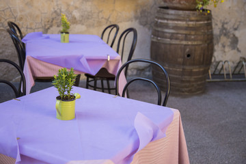 image of restaurant tables with purple tablecloth and decorative plant