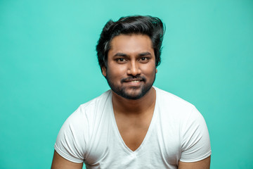 close up portrait of cunning Indian male pretending that he is smiling.Hindoo guy is smiling to show sarcasm. derisive face. quizzical look