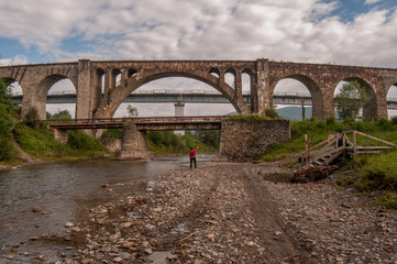Carpathian stone aqueduct with person near it