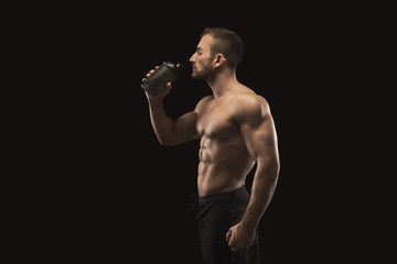 Fototapeta na wymiar Male bodybuilder drinking water after workout